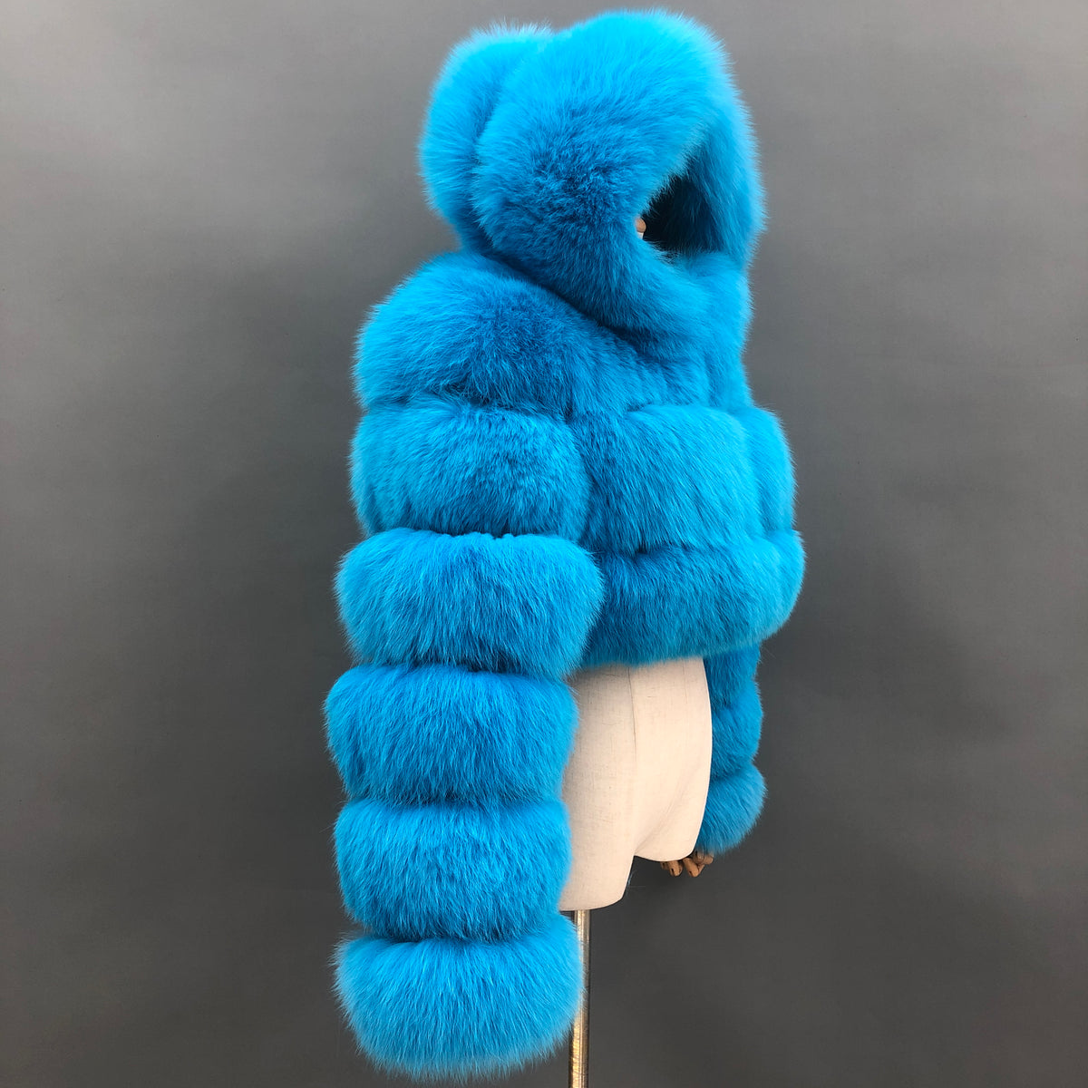 Blue real fox fur cropped hooded jacket with segmented long sleeves, side view